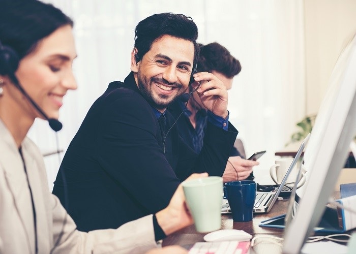 call center agents at desks smiling