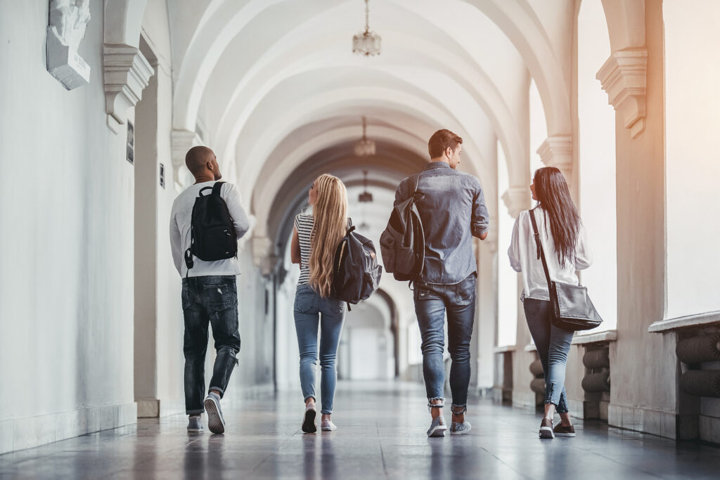 a group of students walking through a large hallway Enrollment Management